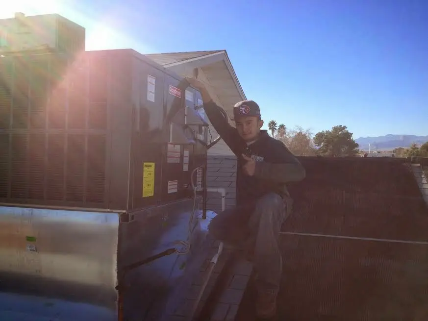 HVAC technician performing Air Duct Cleaning on a rooftop unit in Rancho Cordova